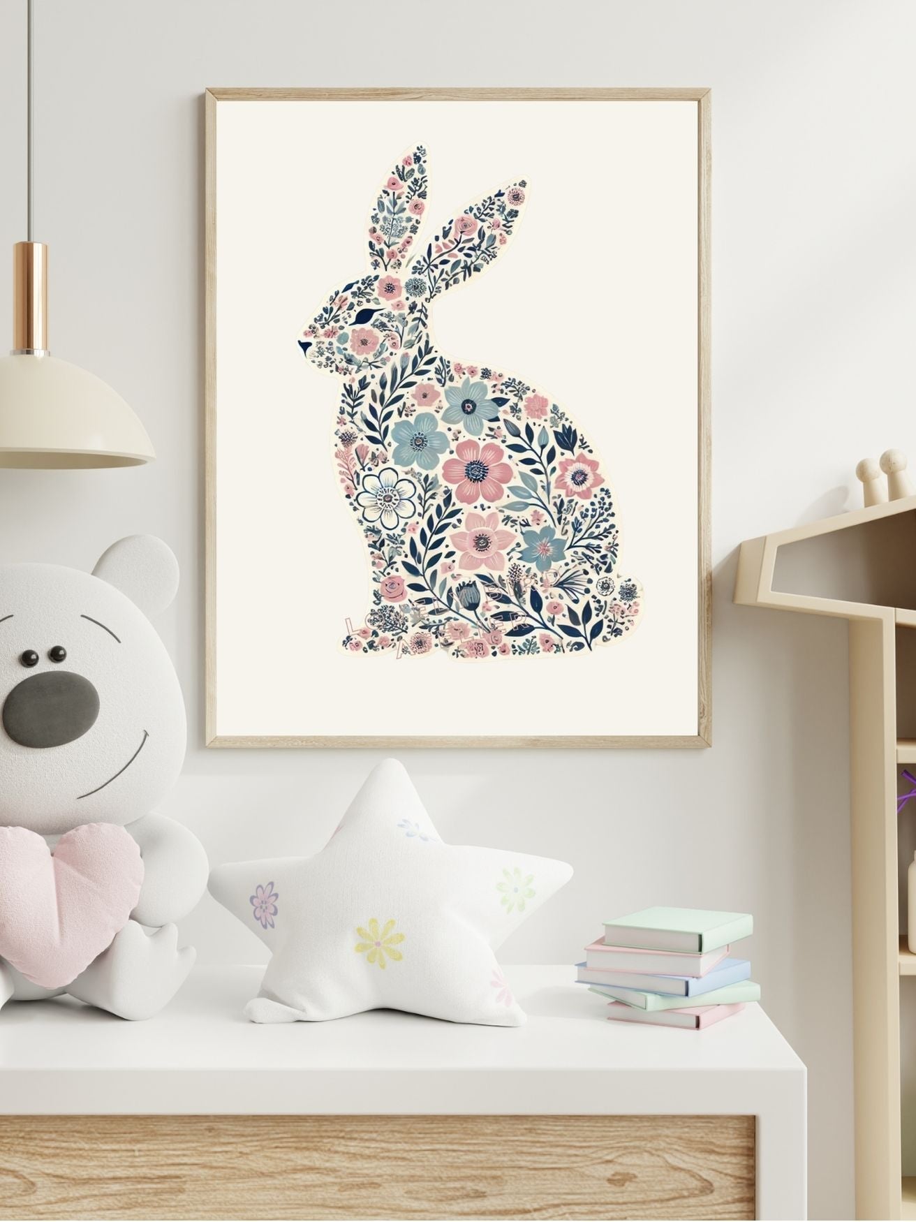 Floral rabbit silhouette artwork in a child's room with teddy bear and star pillow on a white shelf