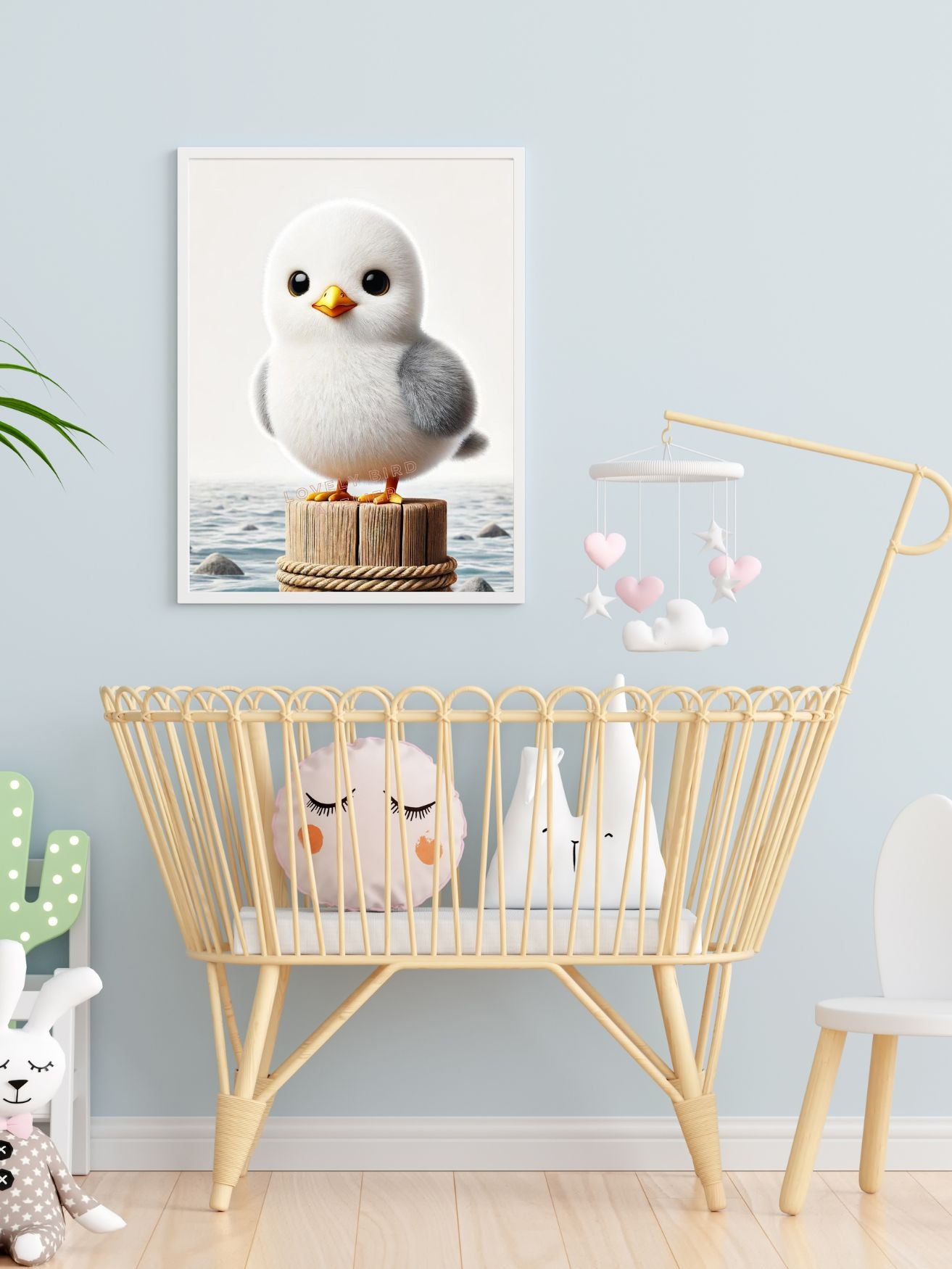 Cute nursery with bird artwork, wooden crib, and soft toys.