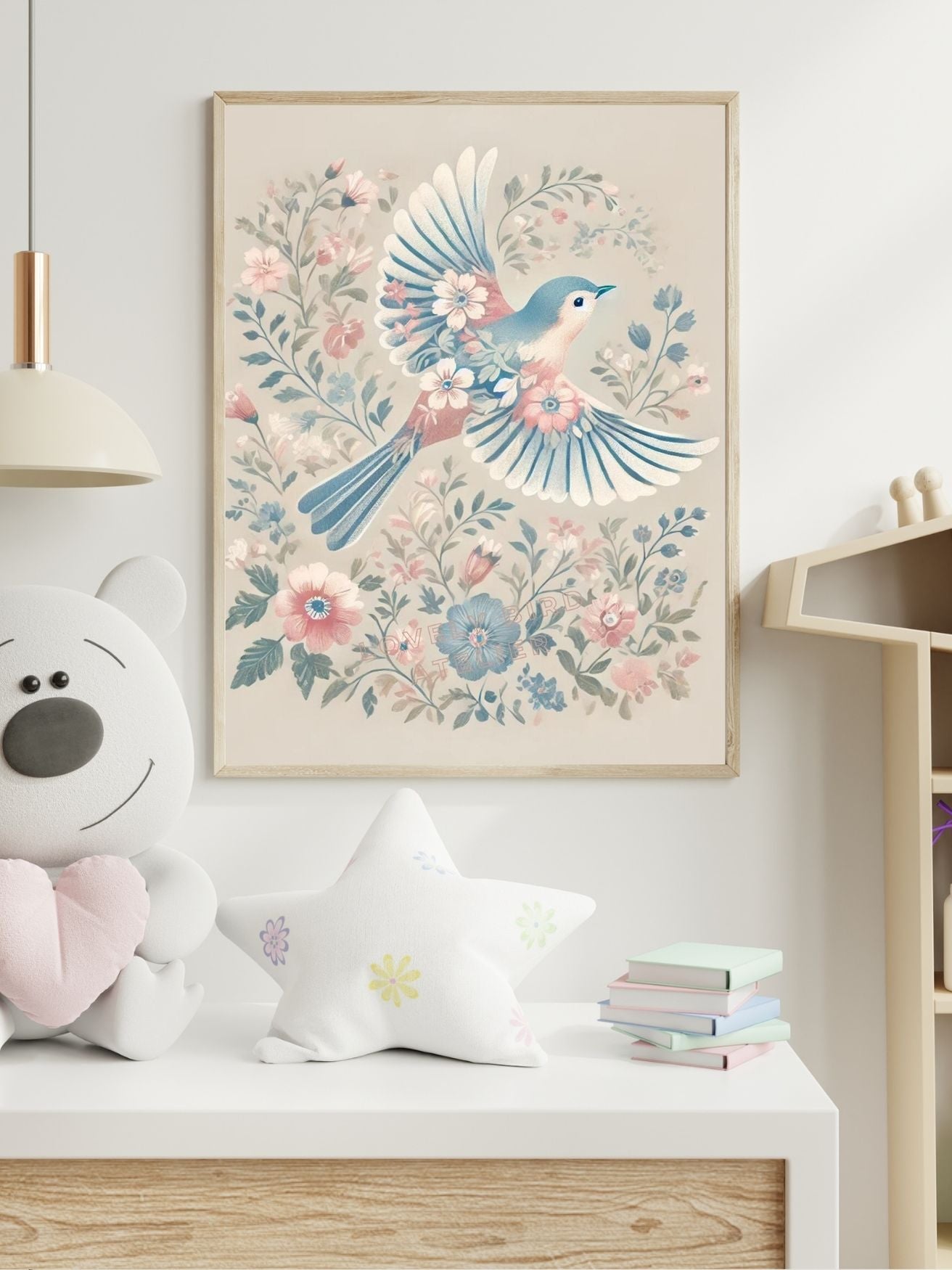 Affiche décorative avec oiseau bleu volant parmi des fleurs roses et bleues accrochée au-dessus d'une table dans une chambre d'enfant.