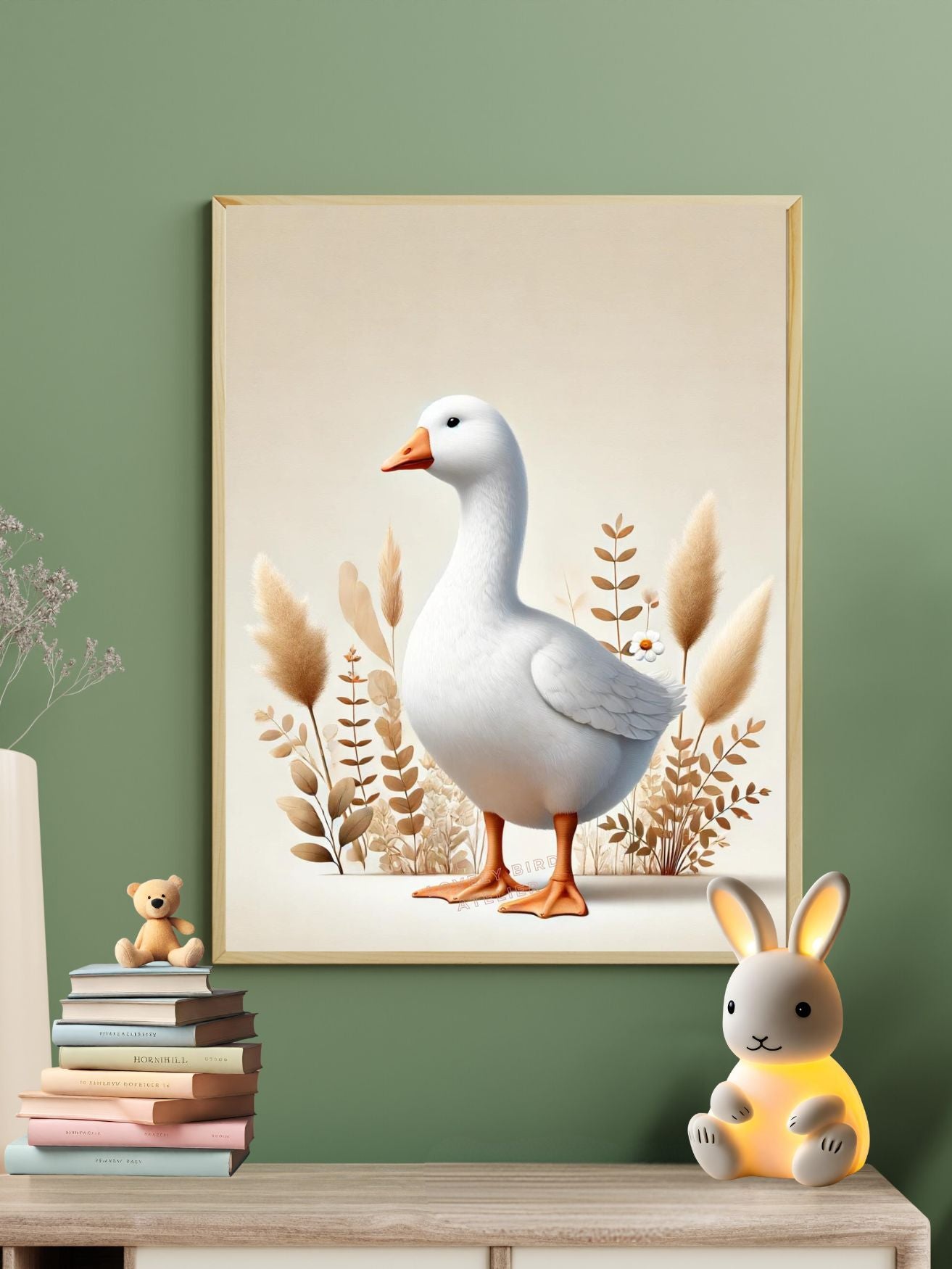 Tableau d'oie blanche dans un intérieur moderne avec des décorations comme une pile de livres et une veilleuse lapin.