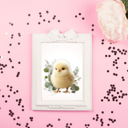 Un poussin moelleux dans un cadre photo blanc sur fond rose avec pétales de fleurs et confettis noirs.