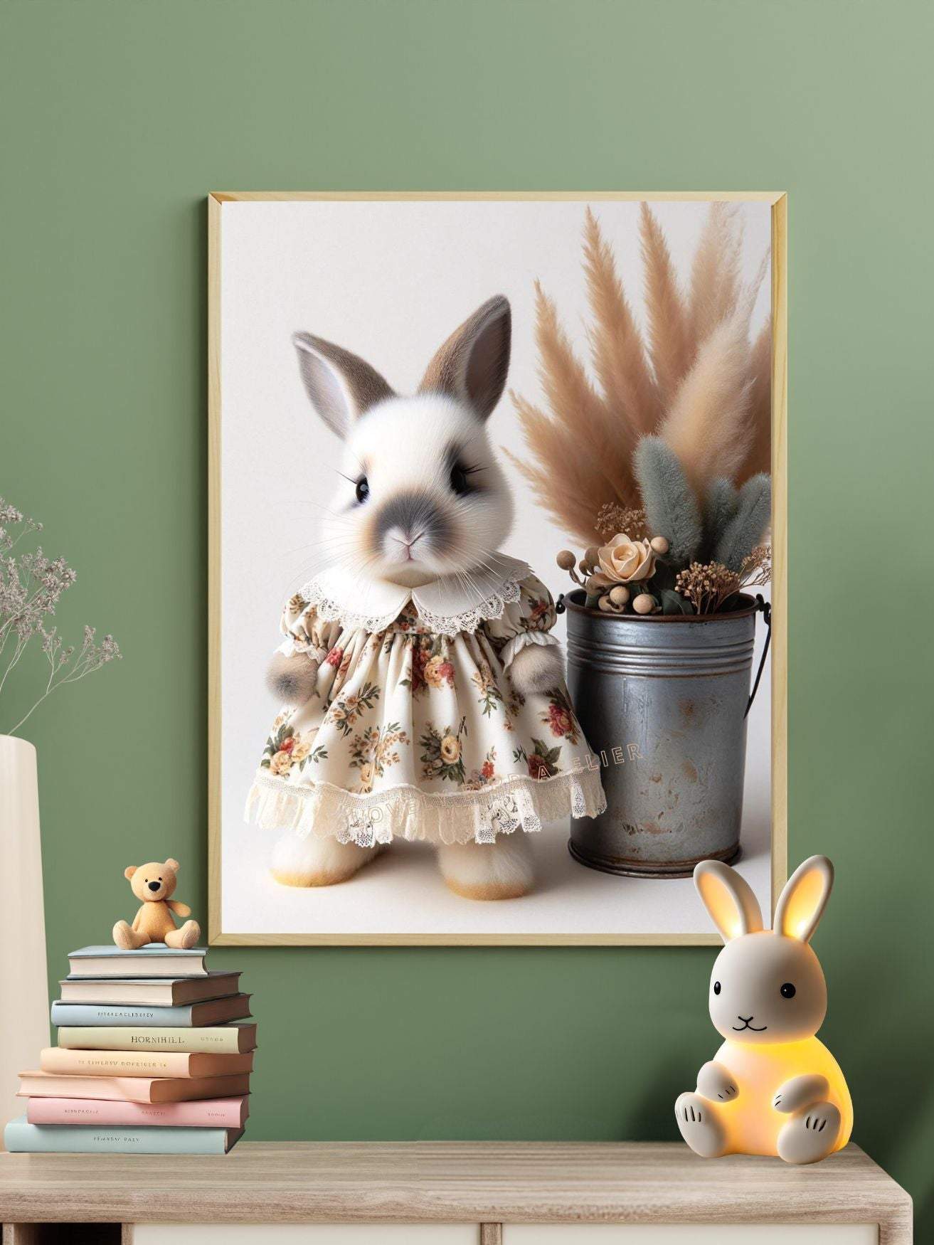 Tableau de lapin mignon en robe fleurie avec décorations végétales, placé dans un cadre doré sur un mur vert.